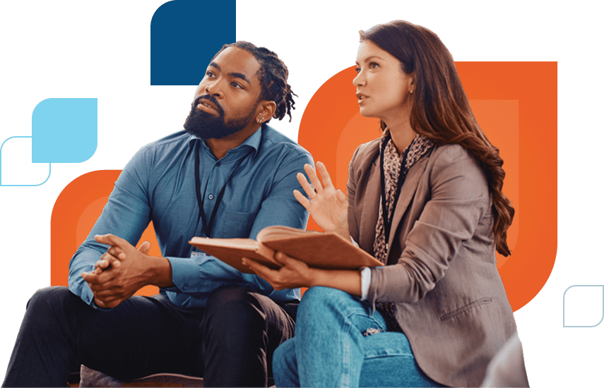 Man and Woman at a conference talking with each other while sitting down.