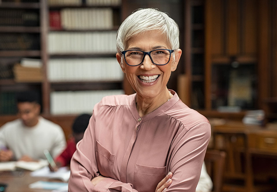 a woman in a library smiles at the camera