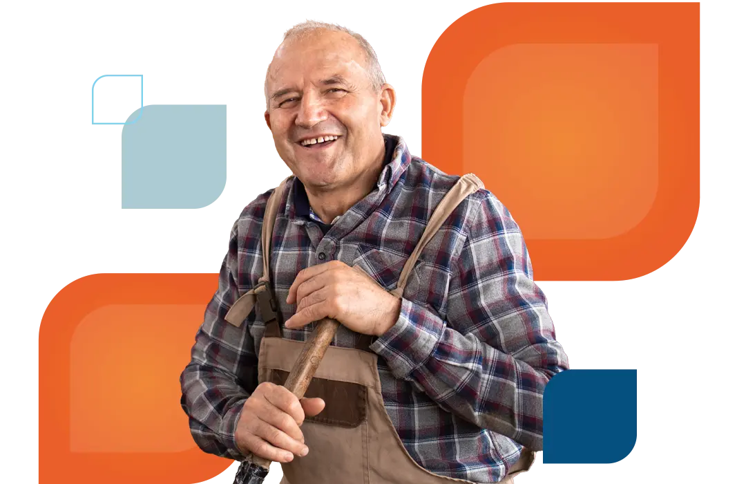a man wearing farming clothes smiles at the camera