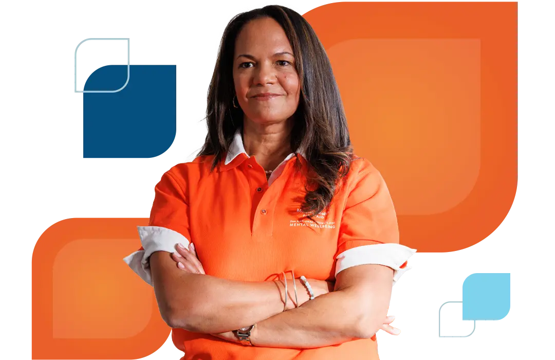 a woman stands with her arms crossed and smiling